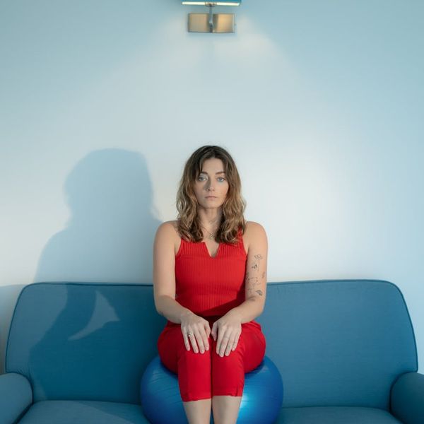 A person sitting calmly in a bright room, looking serene and focused.